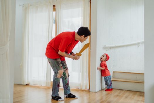 Father and son enjoying playful time together by the stairs at home.