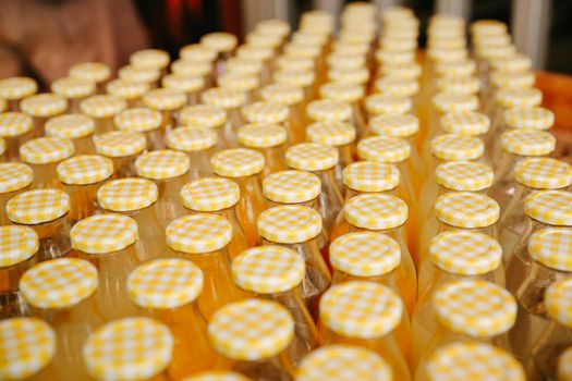 Rows of bottles with yellow checkered caps in a symmetrical pattern.